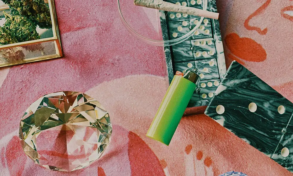 Flat lay of cannabis-related items including a lighter, decorative tray, and crystal ornament on a colorful background Flat lay of cannabis-related items including a lighter, decorative tray, and crystal ornament on a colorful background